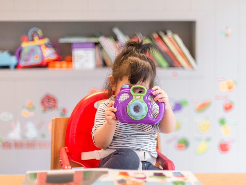 Child holding a toy camera